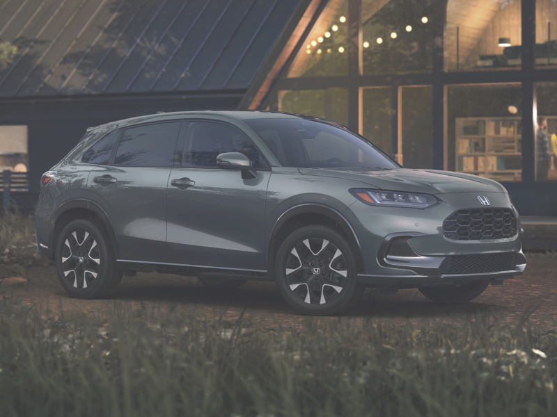 3/4 front side view of grey HR-V park in front of an A-frame cottage. 