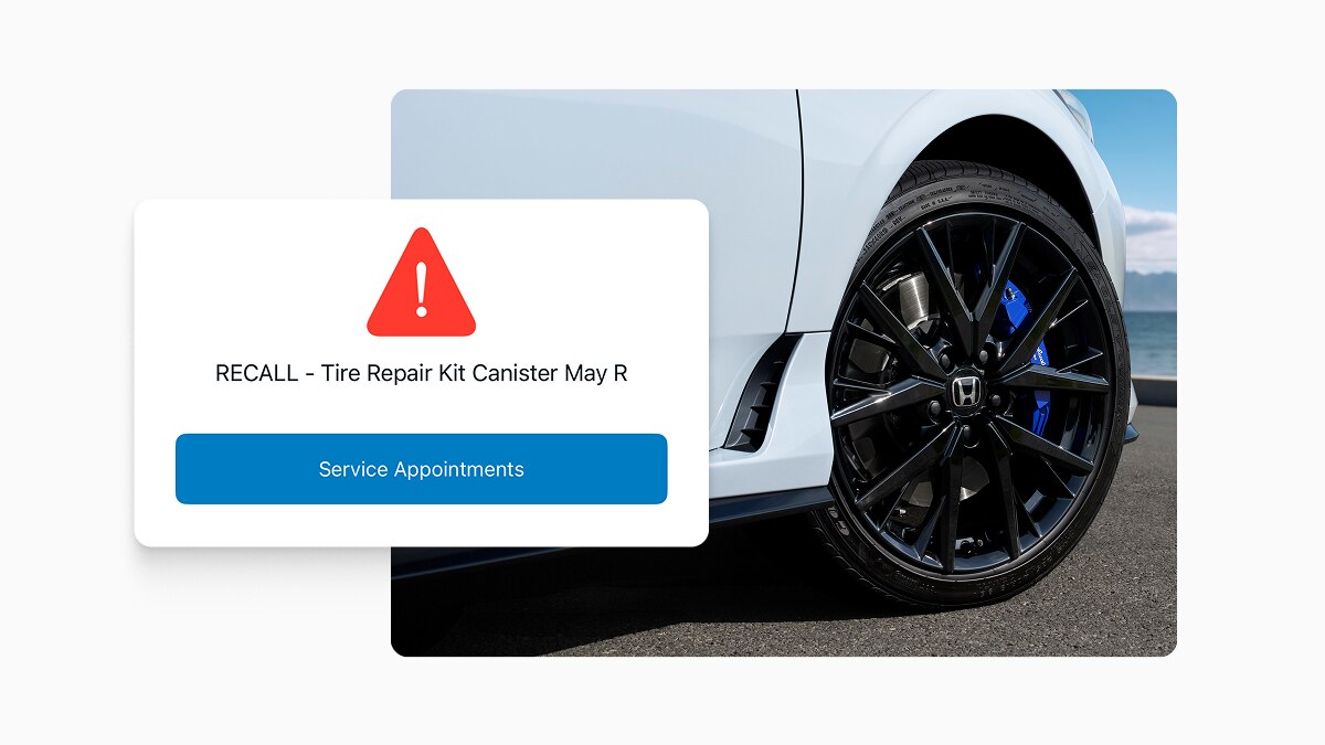 Screencapture of HondaLink app demonstrating a recall notification, overlayed over the image of a Honda vehicle wheel. 