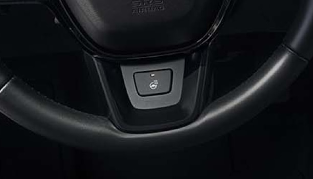Gros plan du bouton de volant chauffant sur le volant.