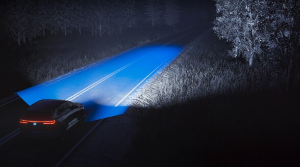 3/4 rear view of a car driving at night, with blue graphic overlay emphasizing its headlights illuminating the road ahead.
