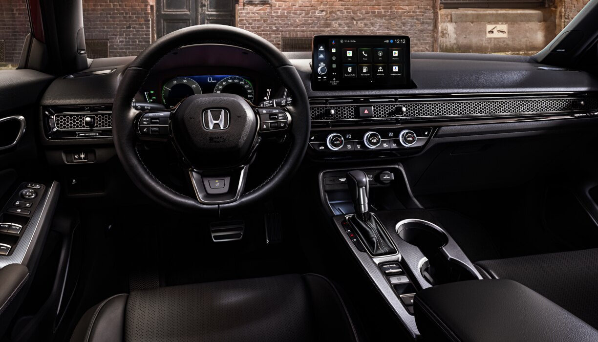 Interior panoramic view of the steering wheel and dashboard on a Hatchback parked in front of brick wall in an old warehouse district.   