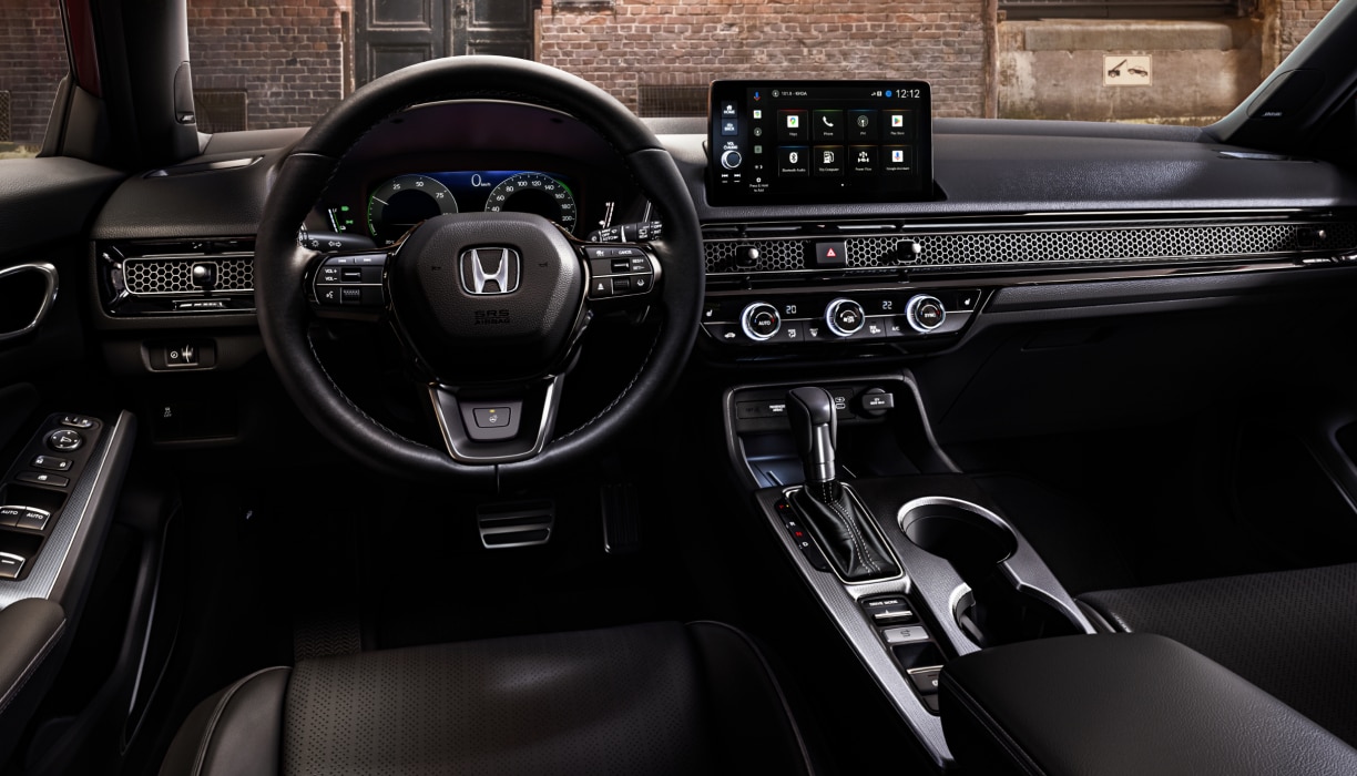Interior panoramic view of the steering wheel and dashboard on a Hatchback parked in front of brick wall in an old warehouse district.