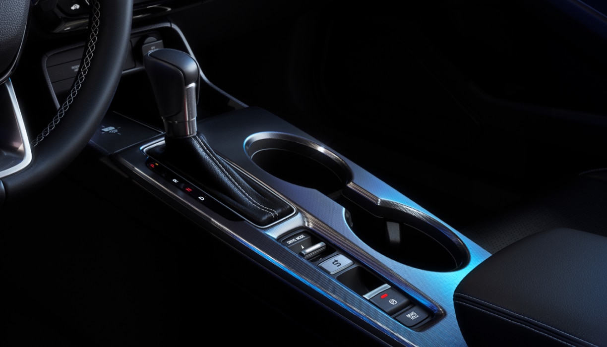 Closeup of gear shifter and cupholder console.