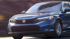 3/4 medium closeup front view of blue Civic Sedan driving.