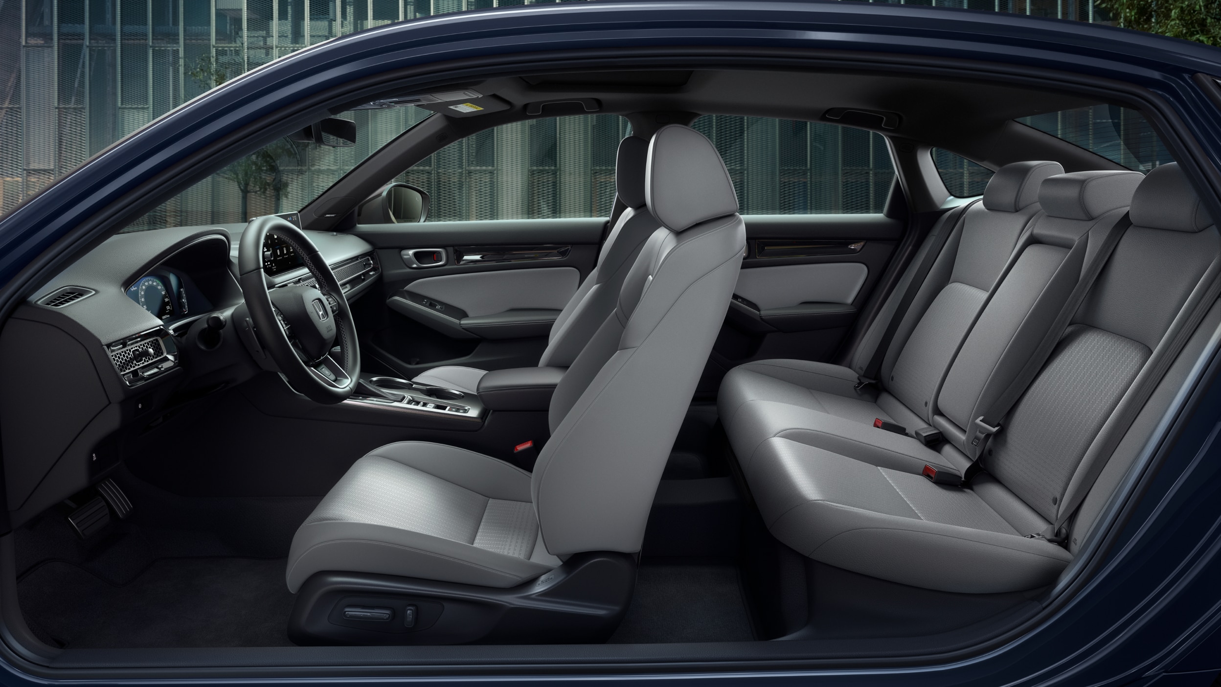 Side panoramic view of a Civic Sedan’s front and rear grey seats.