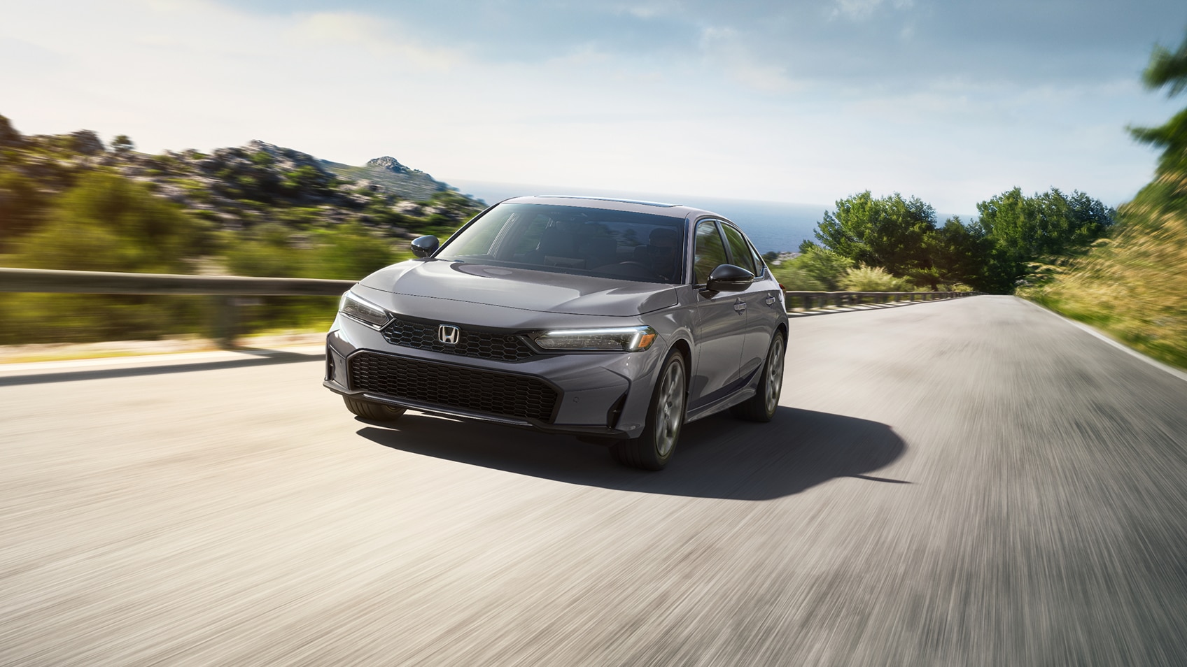 Front view of grey Civic Sedan driving outdoors