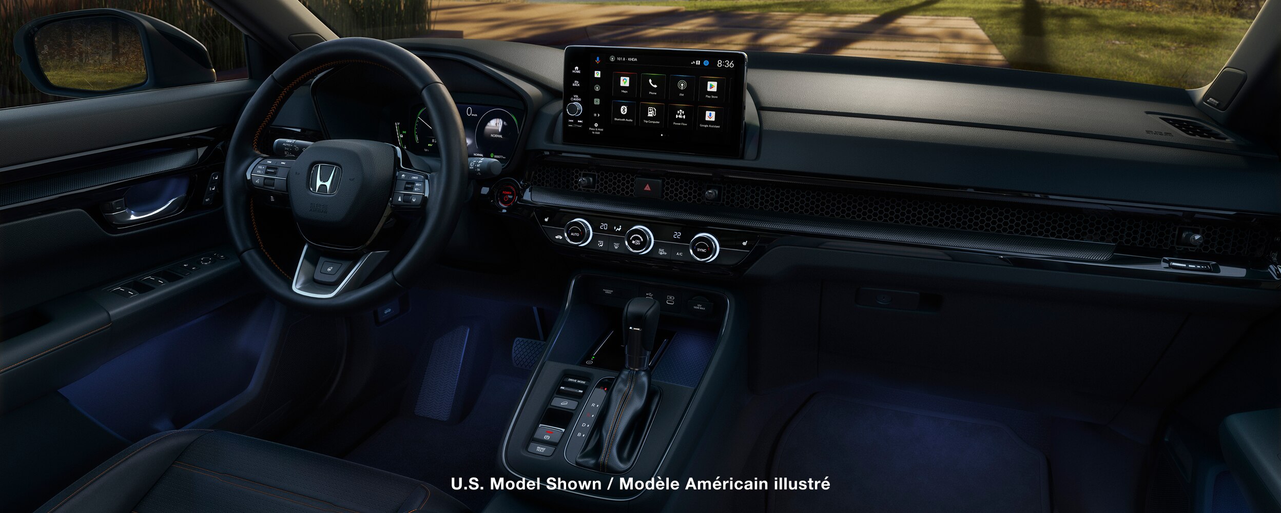 Closeup of interior of the cabin, showing a steering wheel, console and display. 