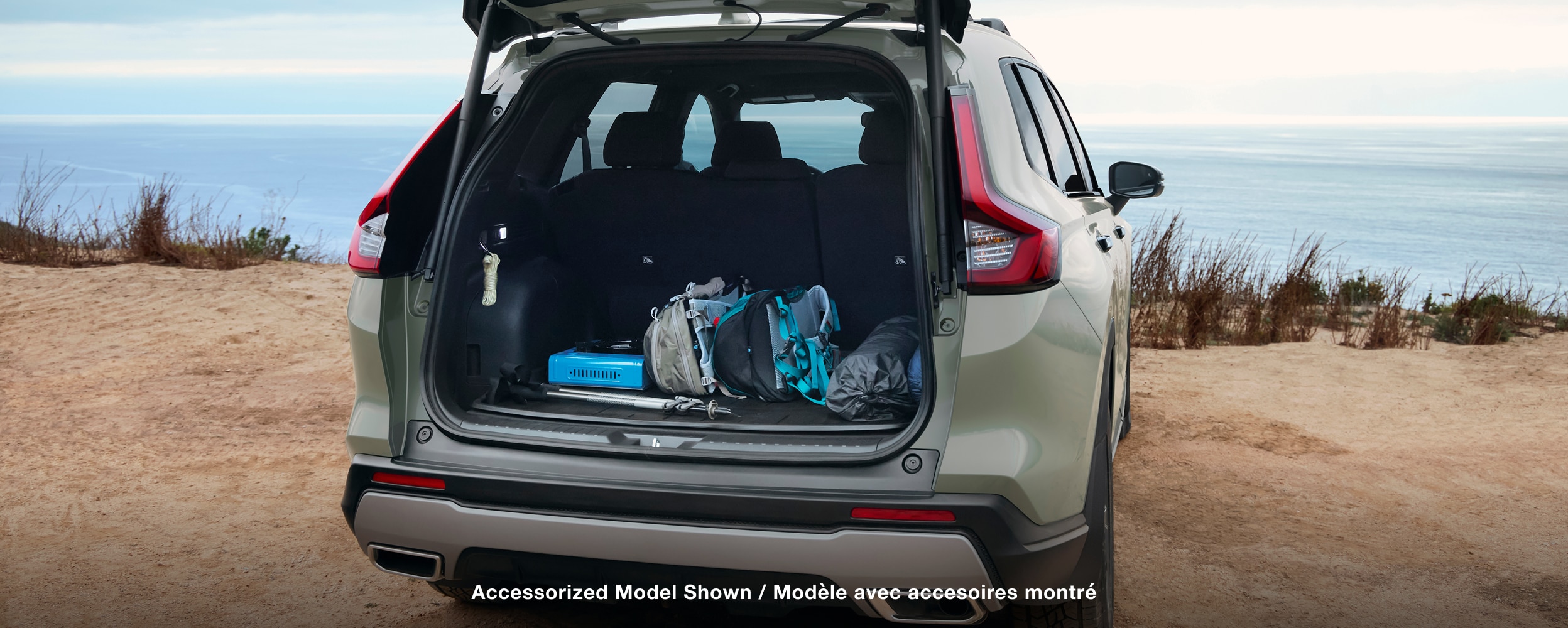 Rear-view of CR-V parked in a moutnain range with the tailgate open and cargo in the back.
