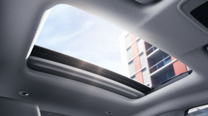 Vue intérieure du toit vitré électrique ouvert laissant entrer la lumière du soleil.