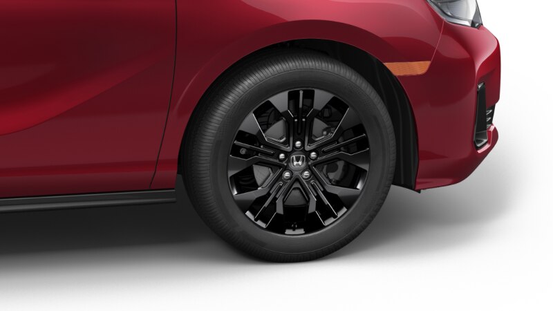 Side view of front end of a red Odyssey on white space, showcasing its black front wheel.
