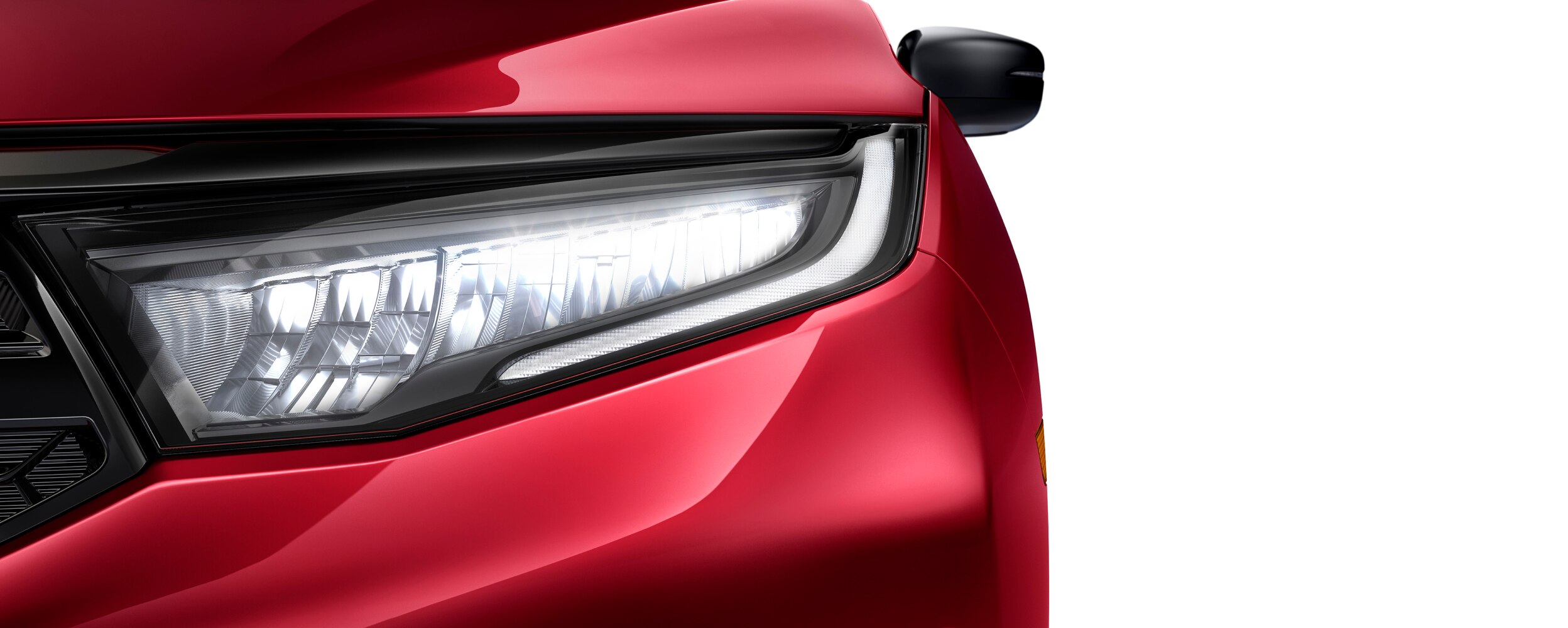Closeup of headlight on red Odyssey on white space.