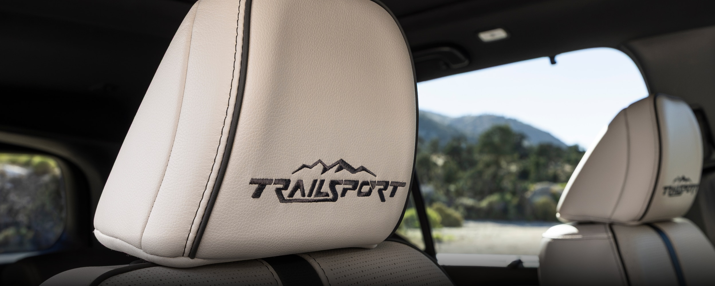 View of front seats on Passport TrailSport Touring Blackout, showcasing the front seat’s black stitching and “TrailSport” logo on headrests.