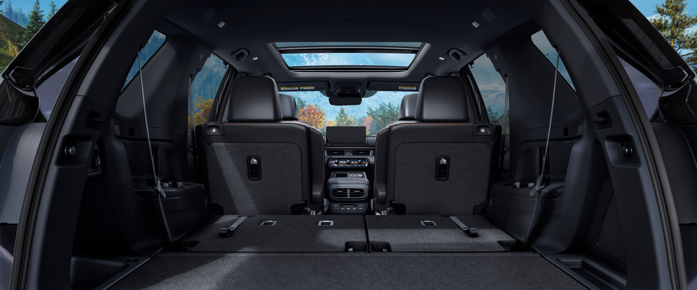 Rear view of the Pilot's interior from the open trunk, with the back row of seats folded down to showcase cargo space.