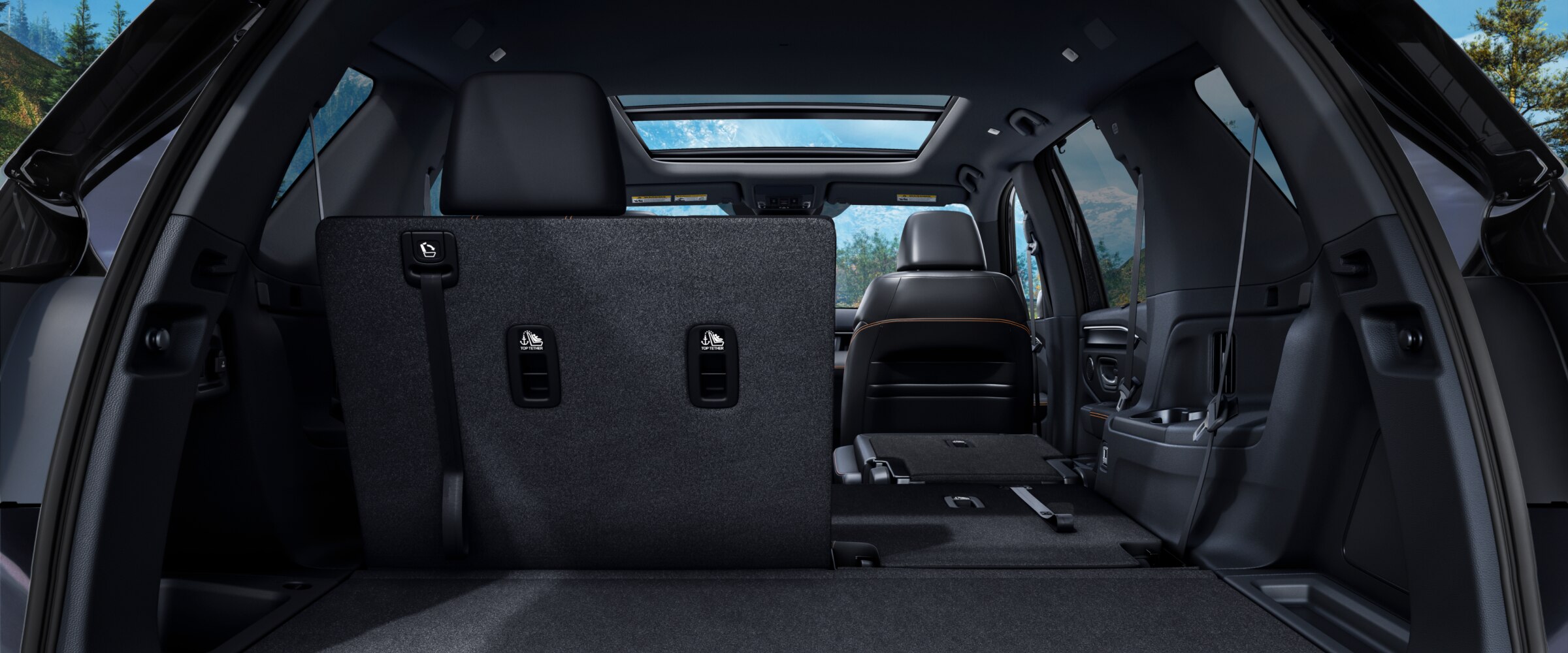 Rear view of the Pilot's interior from the open trunk, with part of the second-row seats folded down to highlight versatility.