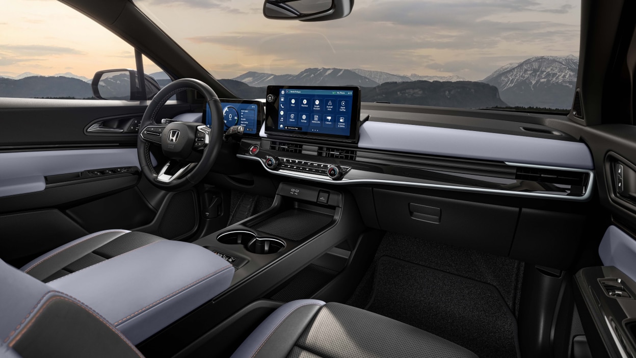 3/4 panoramic interior view of dashboard and new centre console. Out the windshield we see snowy mountaintops.