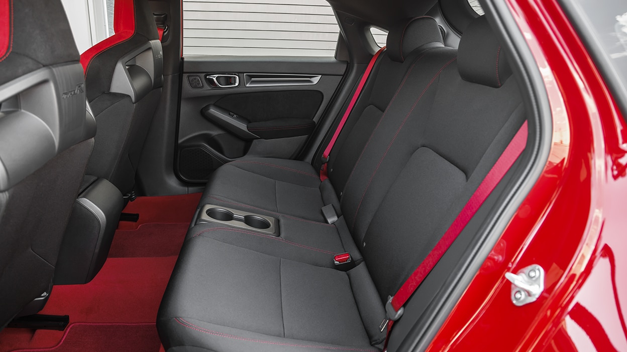 Vue latérale des sièges arrière d’une Type R rouge.