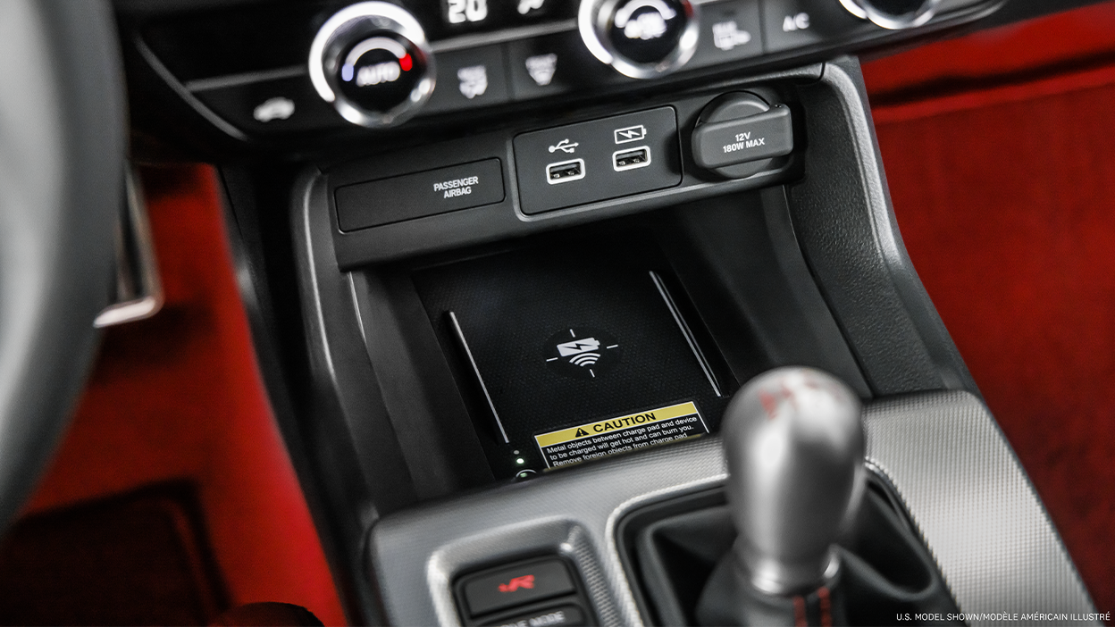 Gros plan du tapis de recharge sans fil dans la console centrale, au-dessus du levier de vitesses.