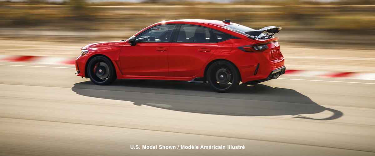 Vue latérale d’une Type R rouge pilotée sur un circuit.