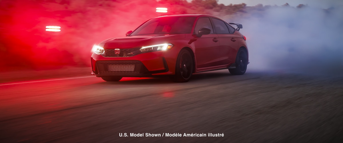 3/4 front view of a red Type R burning rubber on a desert road at dusk.