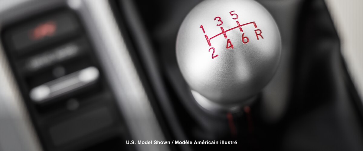 Extreme closeup of top of shifter, displaying the engraved gear map.