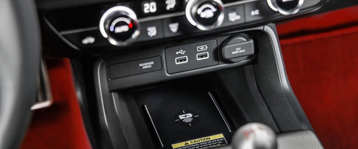 Closeup of wireless charging pad in centre console above gear shifter.