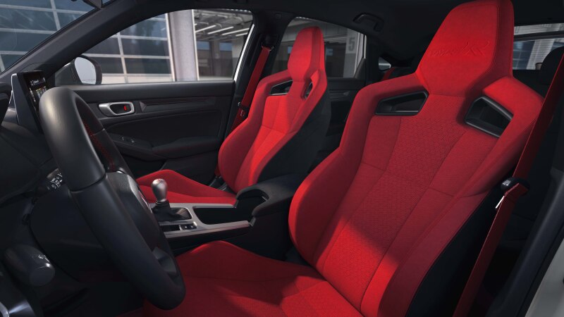 Interior wide shot of the two front red bucket sports seats. 