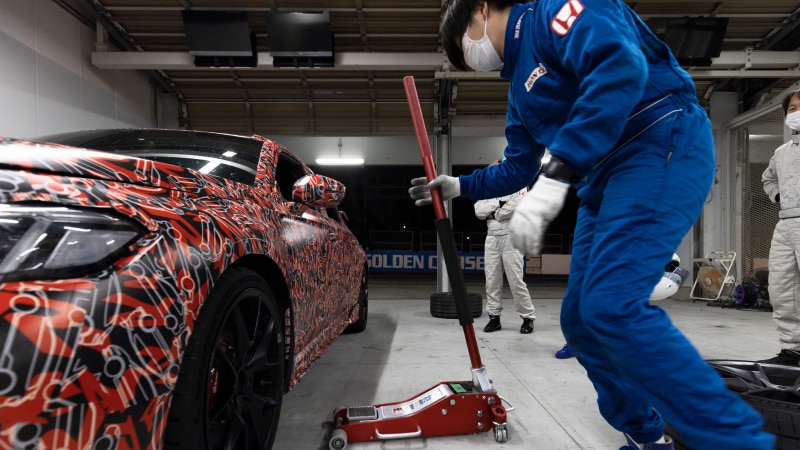 Une Type R avec peinture rouge géniale et monogrammes Type R dans un garage sur le point d’être levée avec un cric.