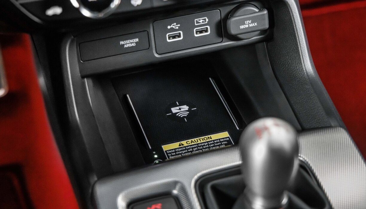 Closeup of wireless charging pad in centre console above gear shifter. 