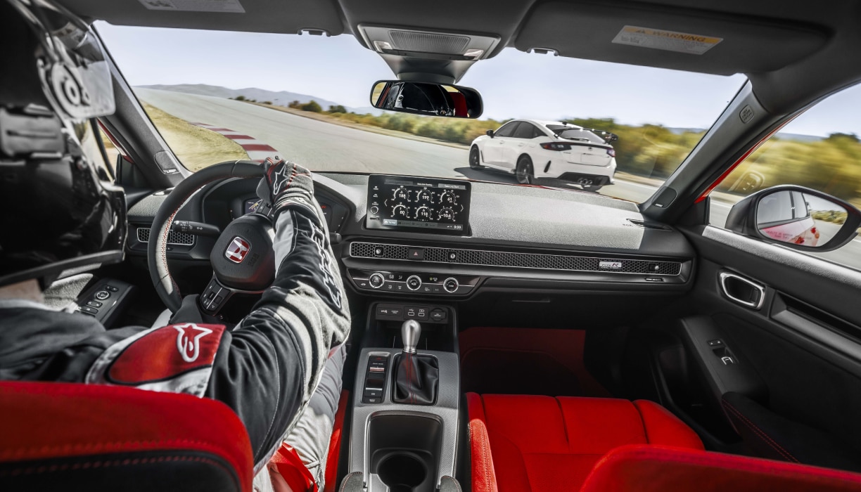 Interior shot, over pilot’s shoulder, showcasing the Type R’s cockpit as it races on a track.