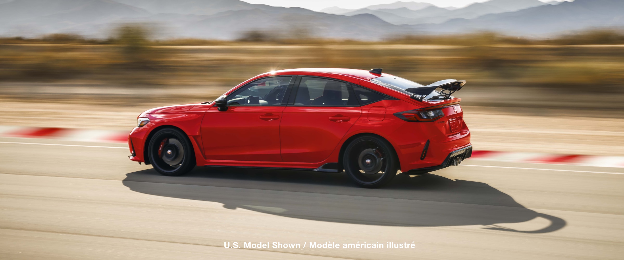 Vue latérale d’une Type R rouge pilotée sur un circuit.