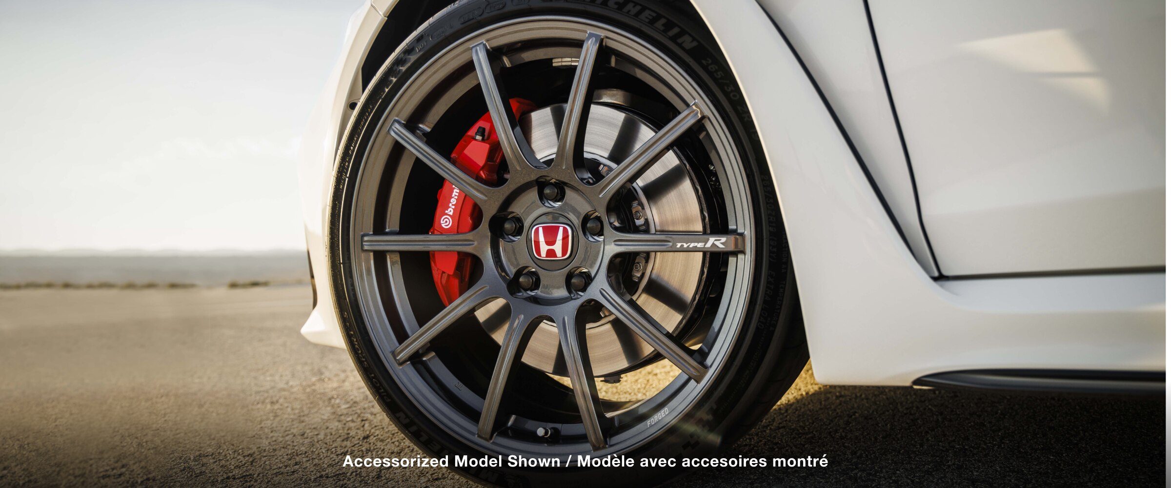 Closeup of wheel on a white Type R; Brembo® caliper is visible.