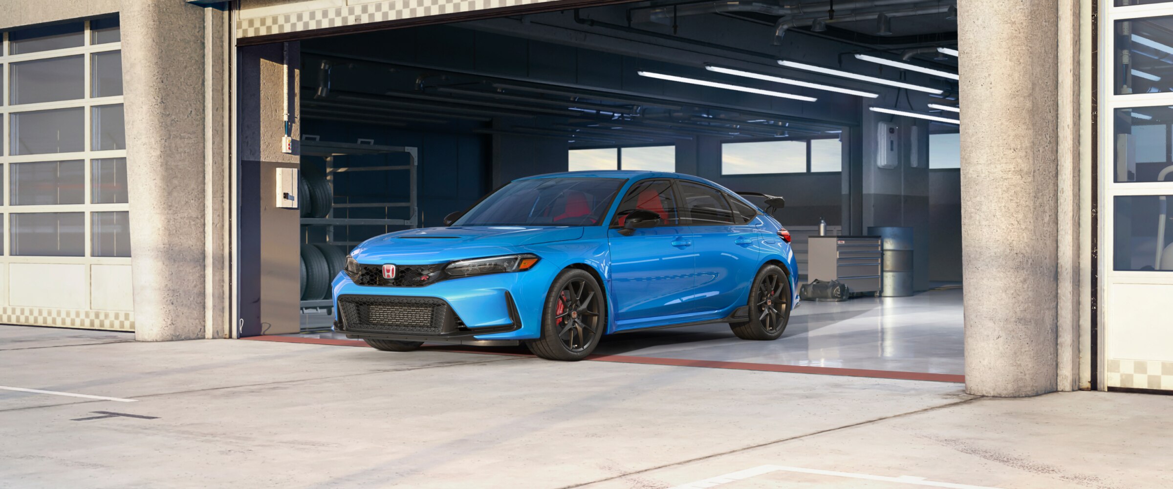 Front view of a blue Type R parked in racing garage