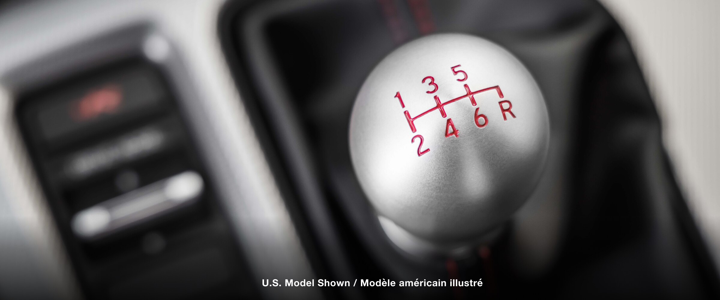 Extreme closeup of top of shifter, displaying the engraved gear map.