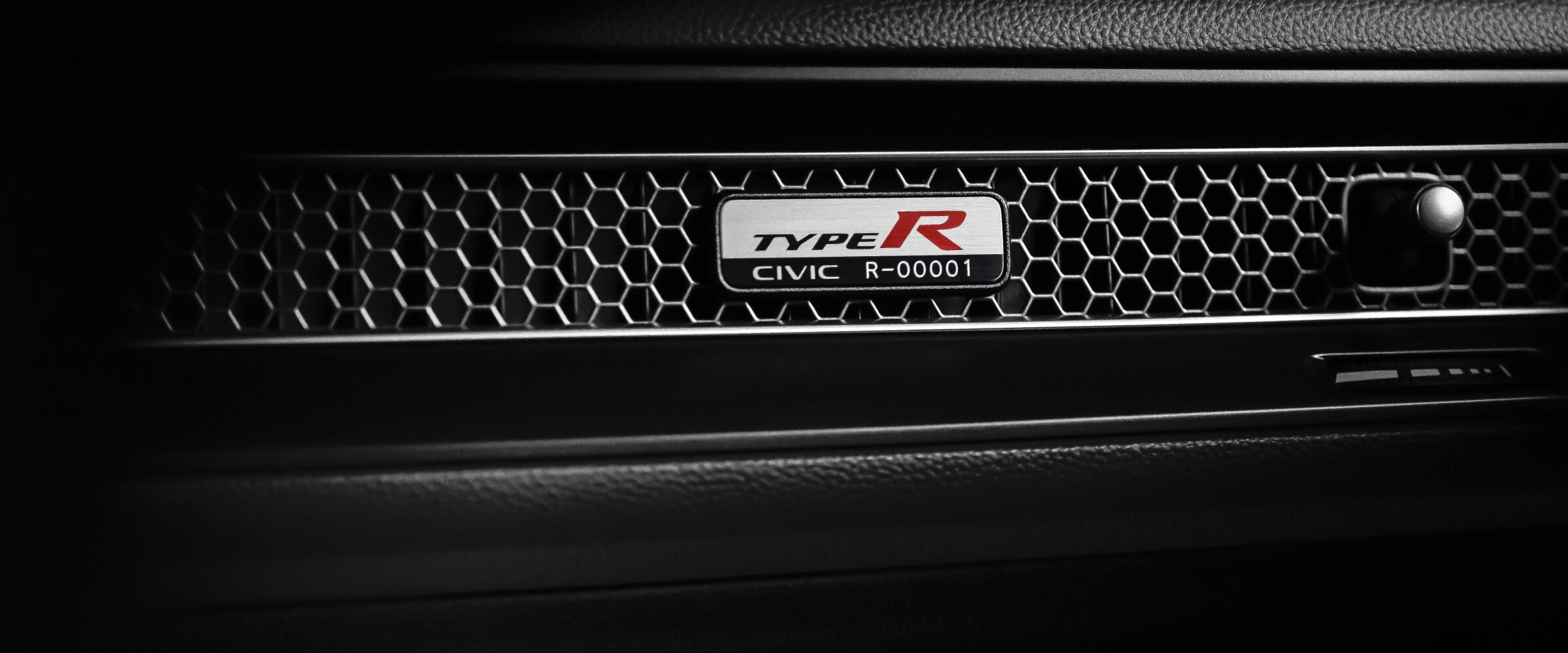 Closeup of Type R serial number plate on the honeycomb vent on the front passenger dashboard.